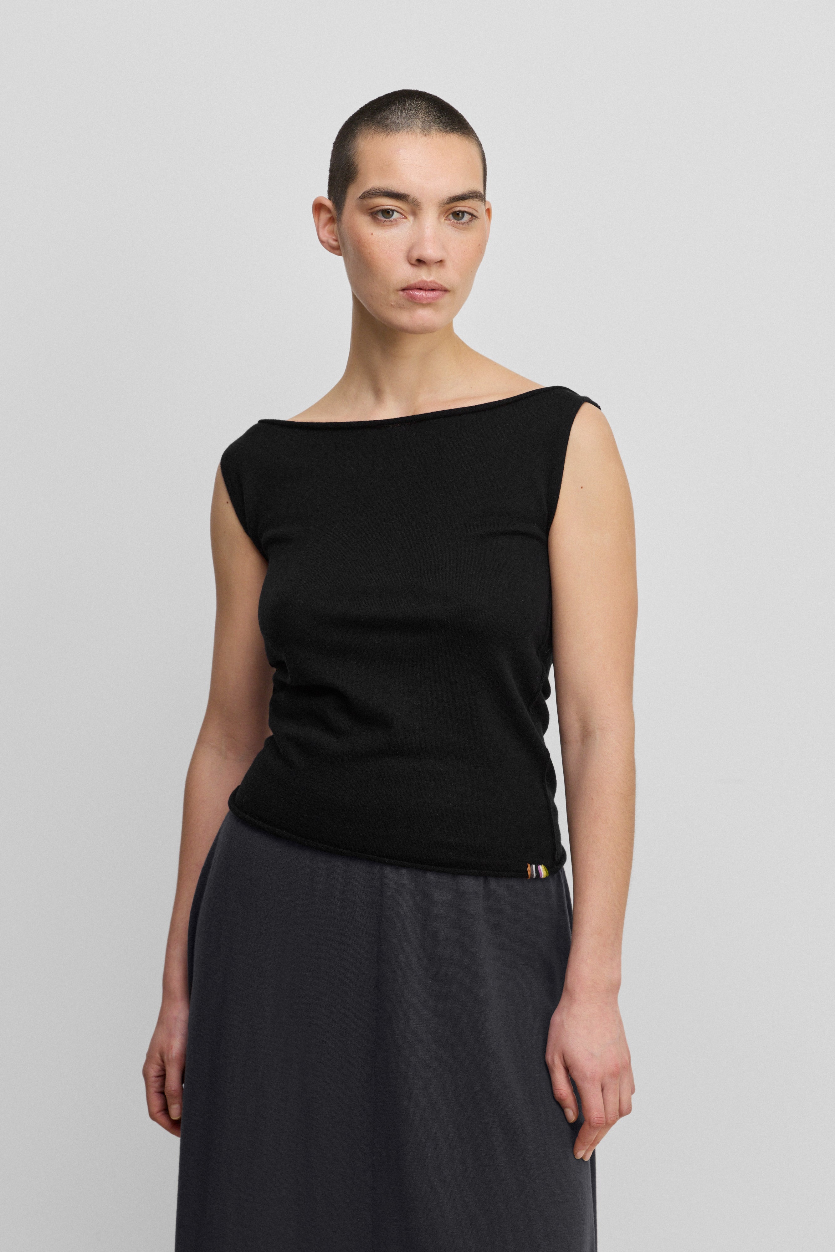 woman wearing a black sleeveless wool cashmere top with a boat neck.