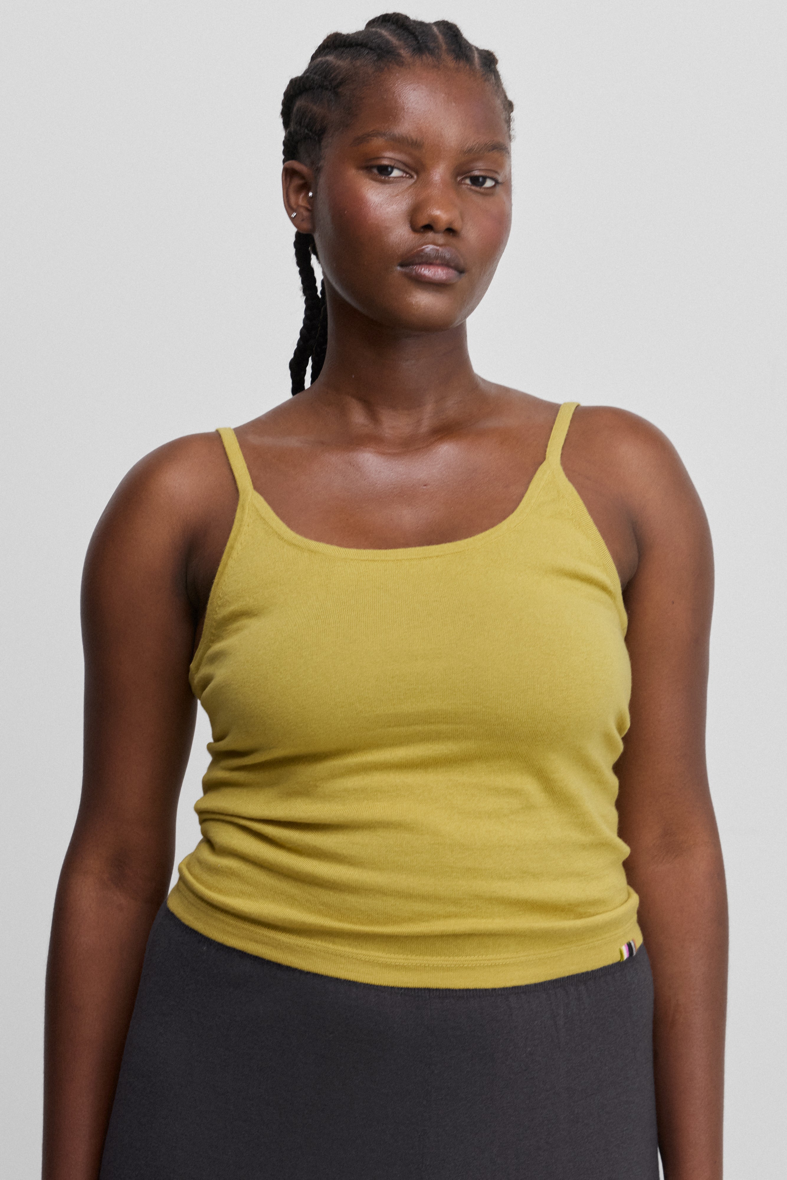 woman wearing a yellow fitted cotton cashmere strap top with a round neckline.