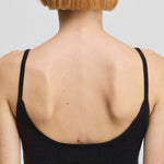 detail of the low back of a black cotton cashmere strap top.