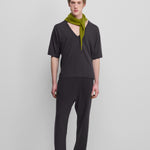 man wearing dark grey loose-fit cashmere pants with a drawstring waistband and side pockets.