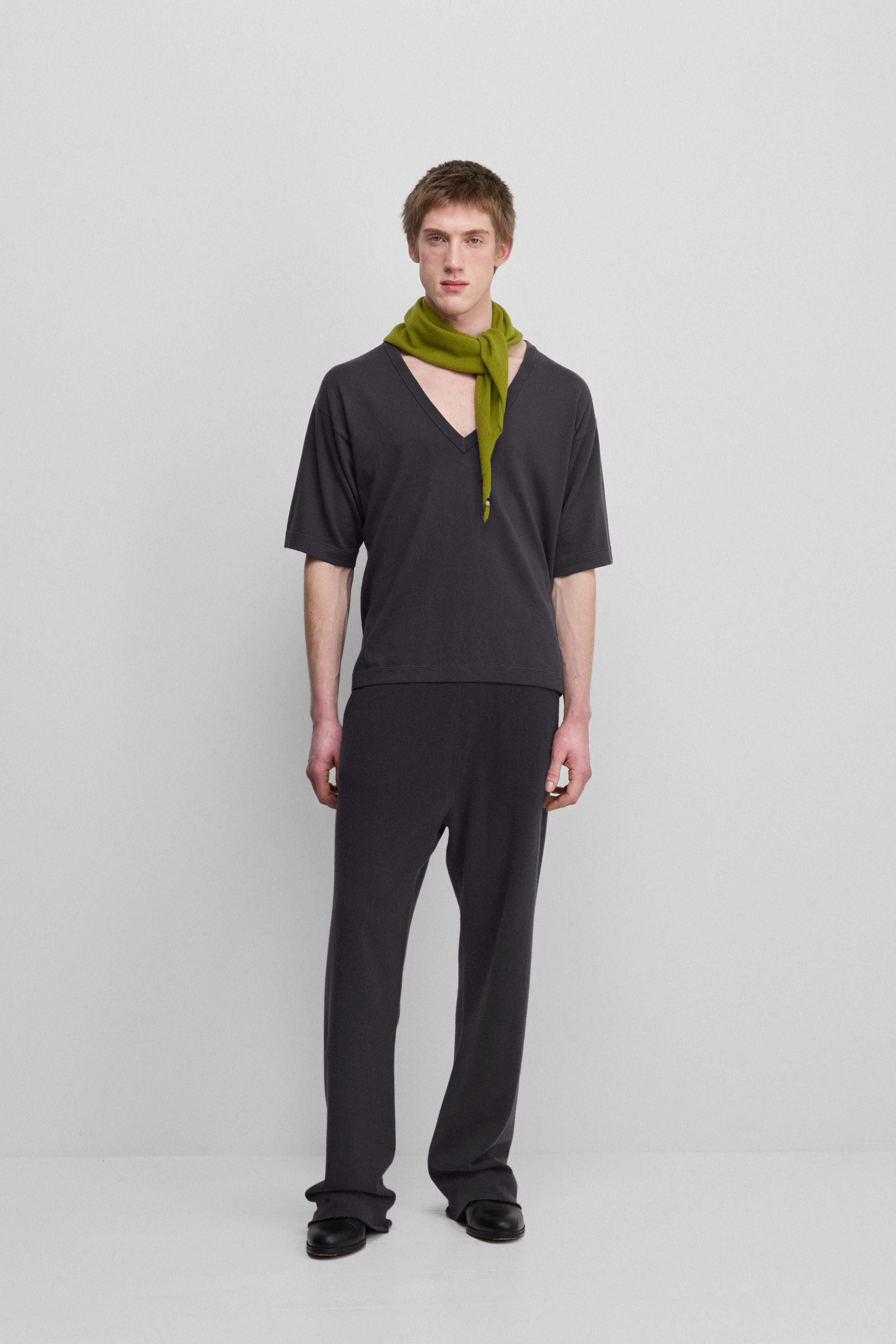 man wearing dark grey loose-fit cashmere pants with a drawstring waistband and side pockets.