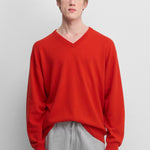 man wearing a bright red cashmere v-neck sweater with ribbed trims.