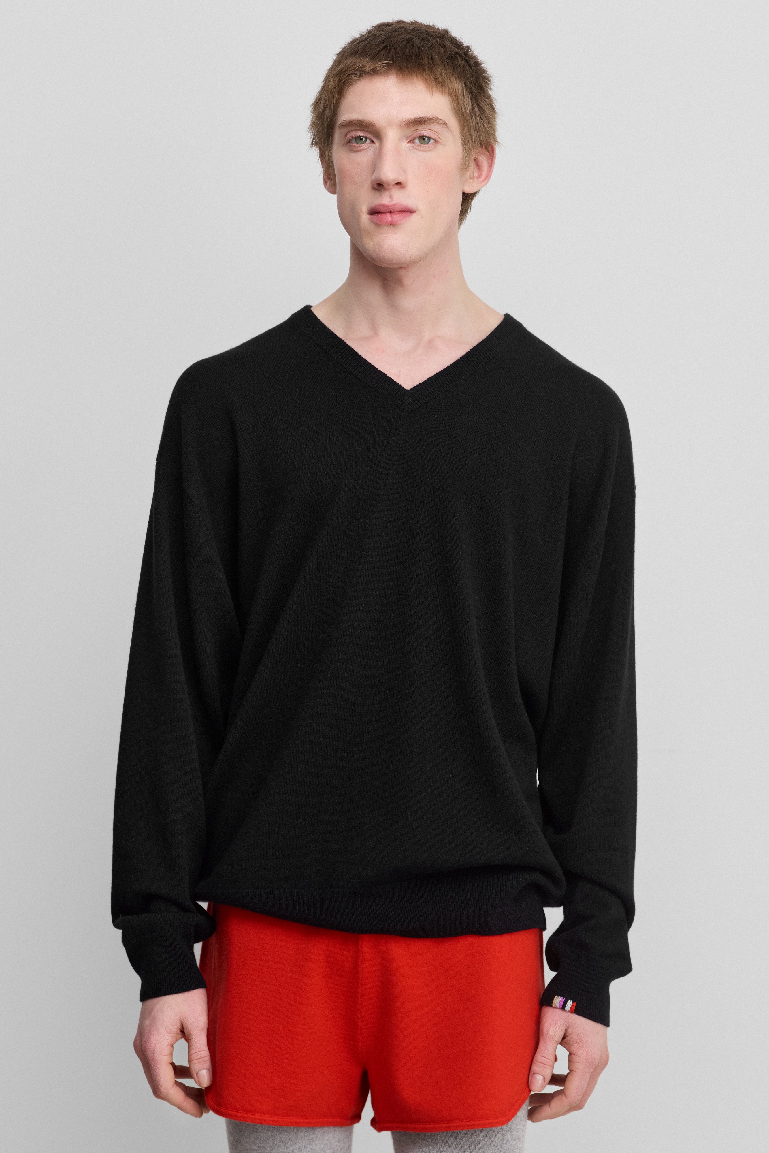 man wearing a black cashmere v-neck sweater with ribbed trims.