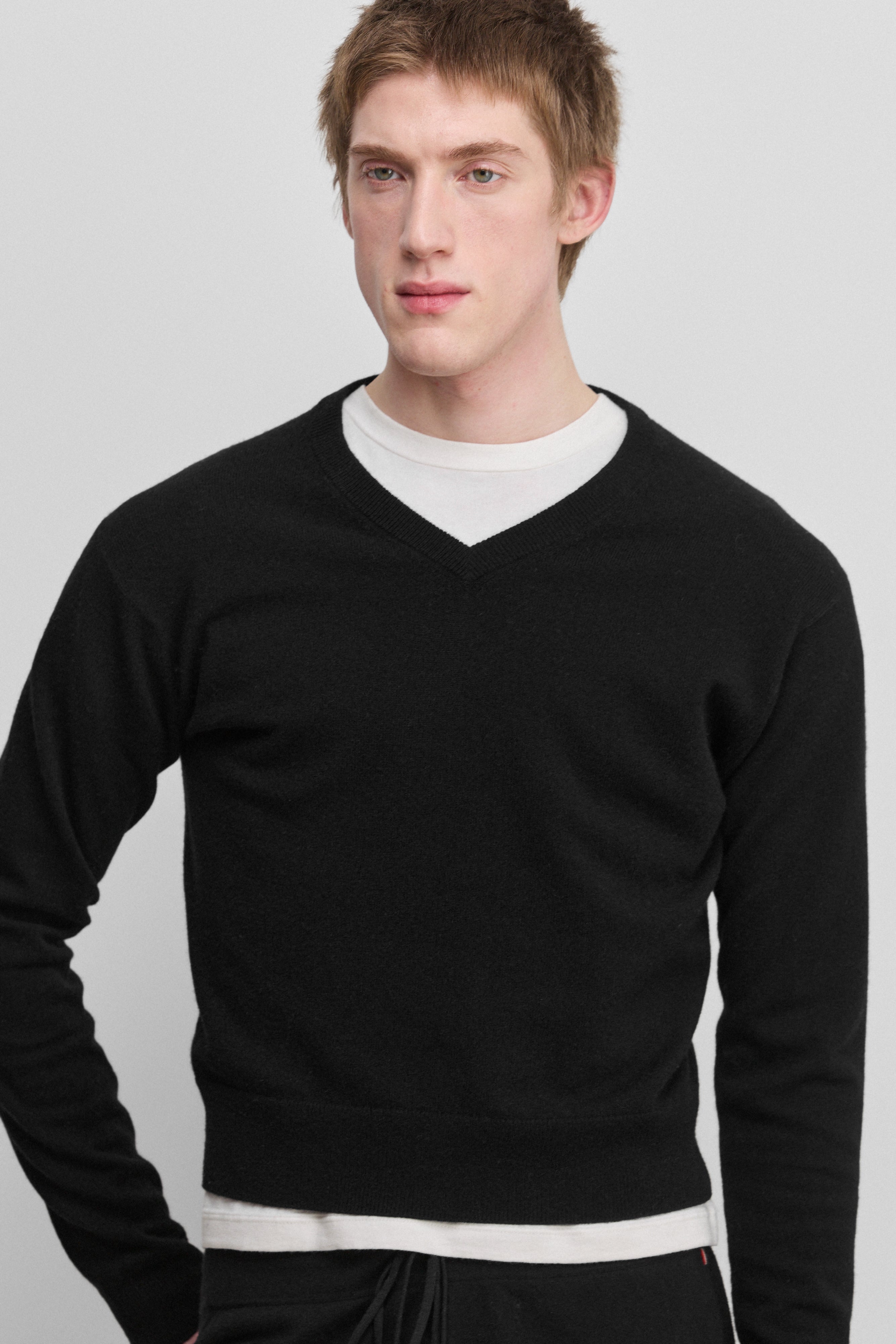 man wearing a black cashmere v-neck sweater.