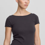 woman wearing a dark grey fitted wool cashmere t-shirt with a boat neck and rolling edge hem.