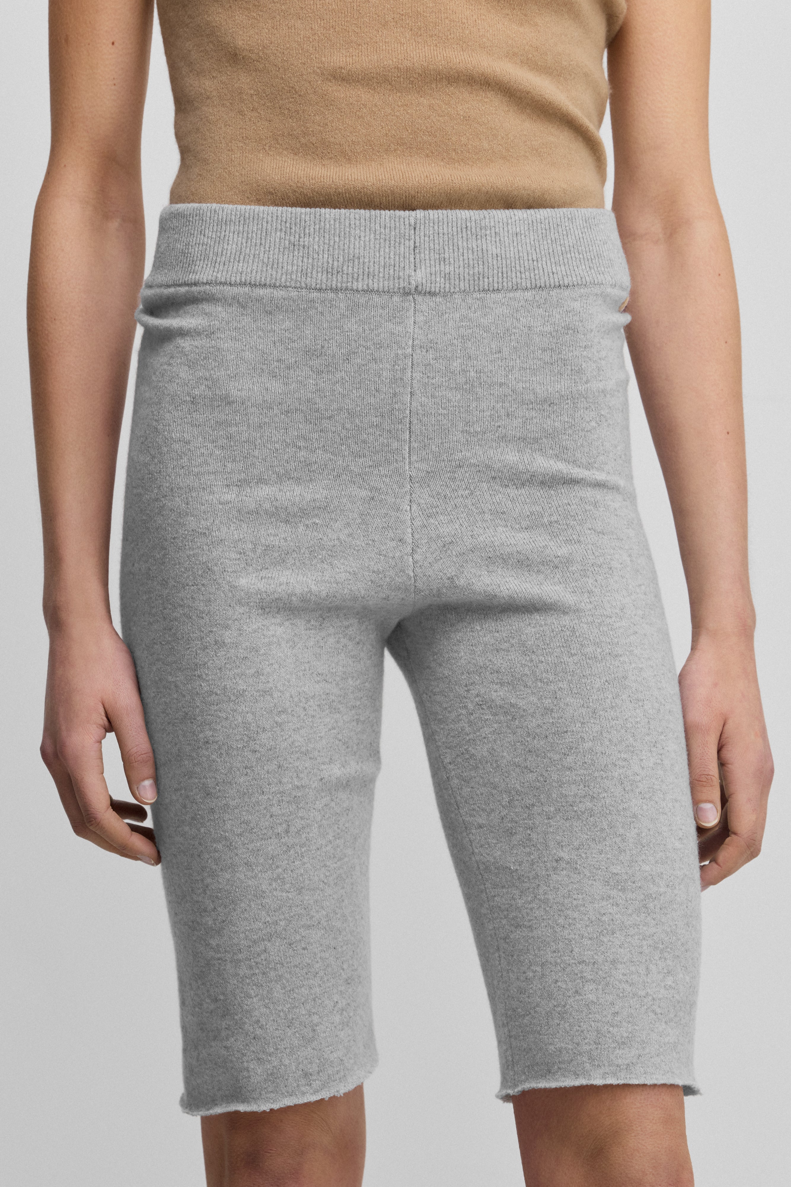 woman wearing light grey cashmere biker shorts with ribbed elasticated waistband.