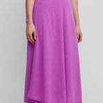 woman wearing a bright pink flared wool cashmere midi skirt with a rolling edge hem.