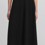 woman wearing a black wool cashmere midi skirt with a rib-knitted waist and a rolling edge hem.