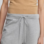 model wearing light grey cotton-cashmere mini-rib shorts with a drawstring and curved hem.