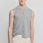 man wearing a light grey sleeveless cotton-cashmere vest with corozo buttons and a crewneck.