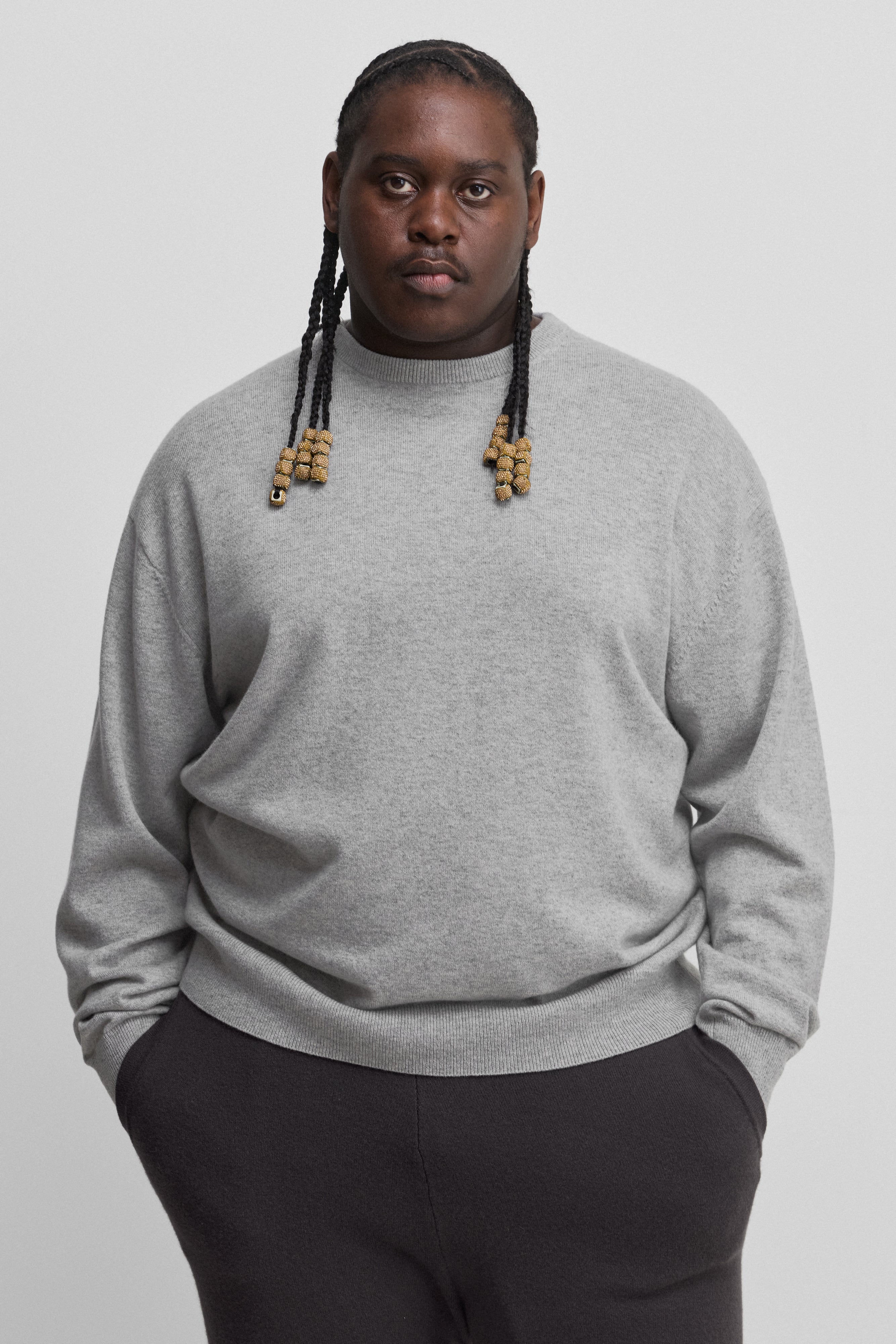 man wearing a light grey loose-fit cashmere crew-neck sweater with ribbed trims.