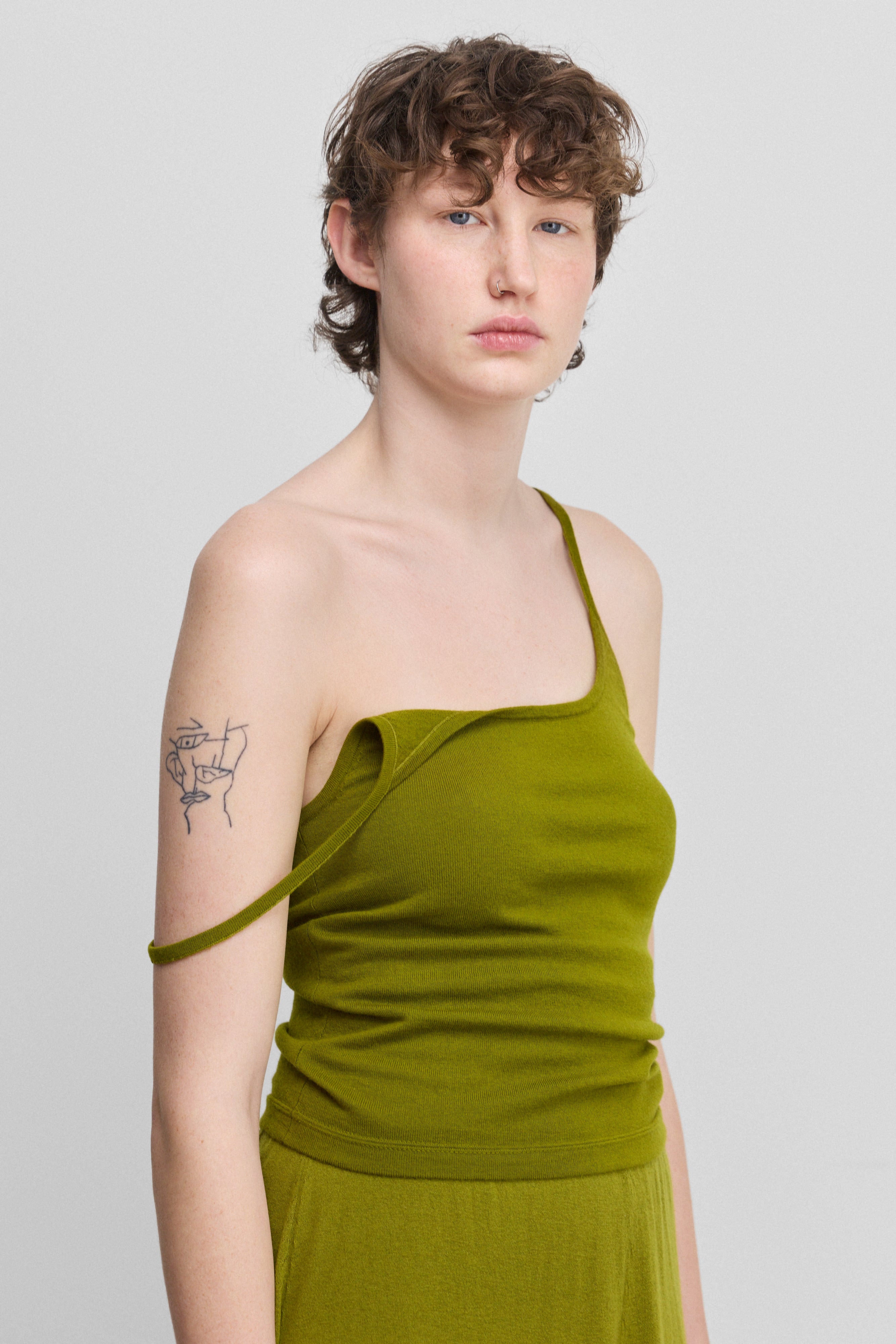 woman wearing a green fitted cotton cashmere strap top with a round neckline.