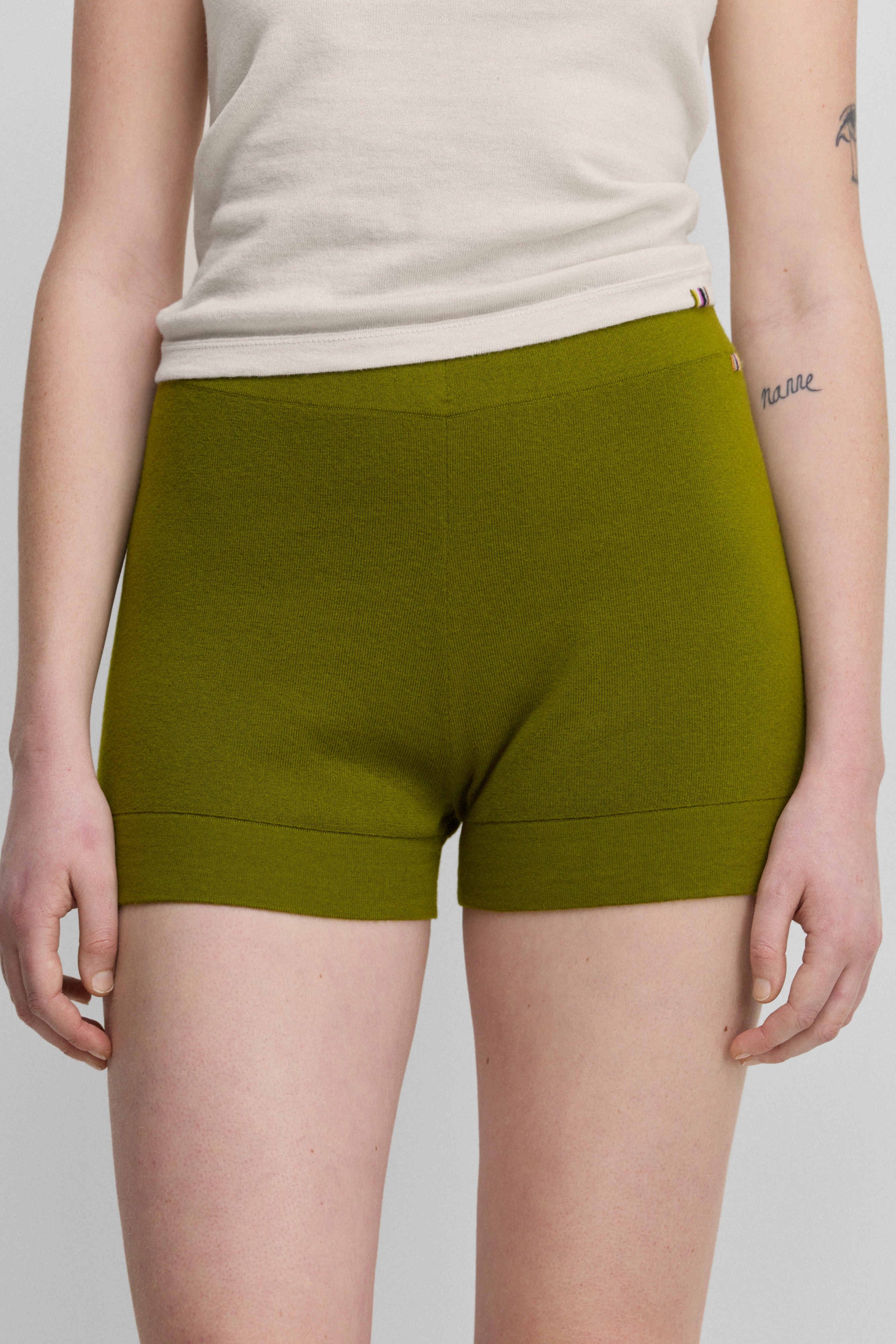 woman wearing fitted green cotton cashmere rib-knit shorts.