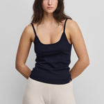 woman wearing a black fitted cotton cashmere strap top with a round neckline.