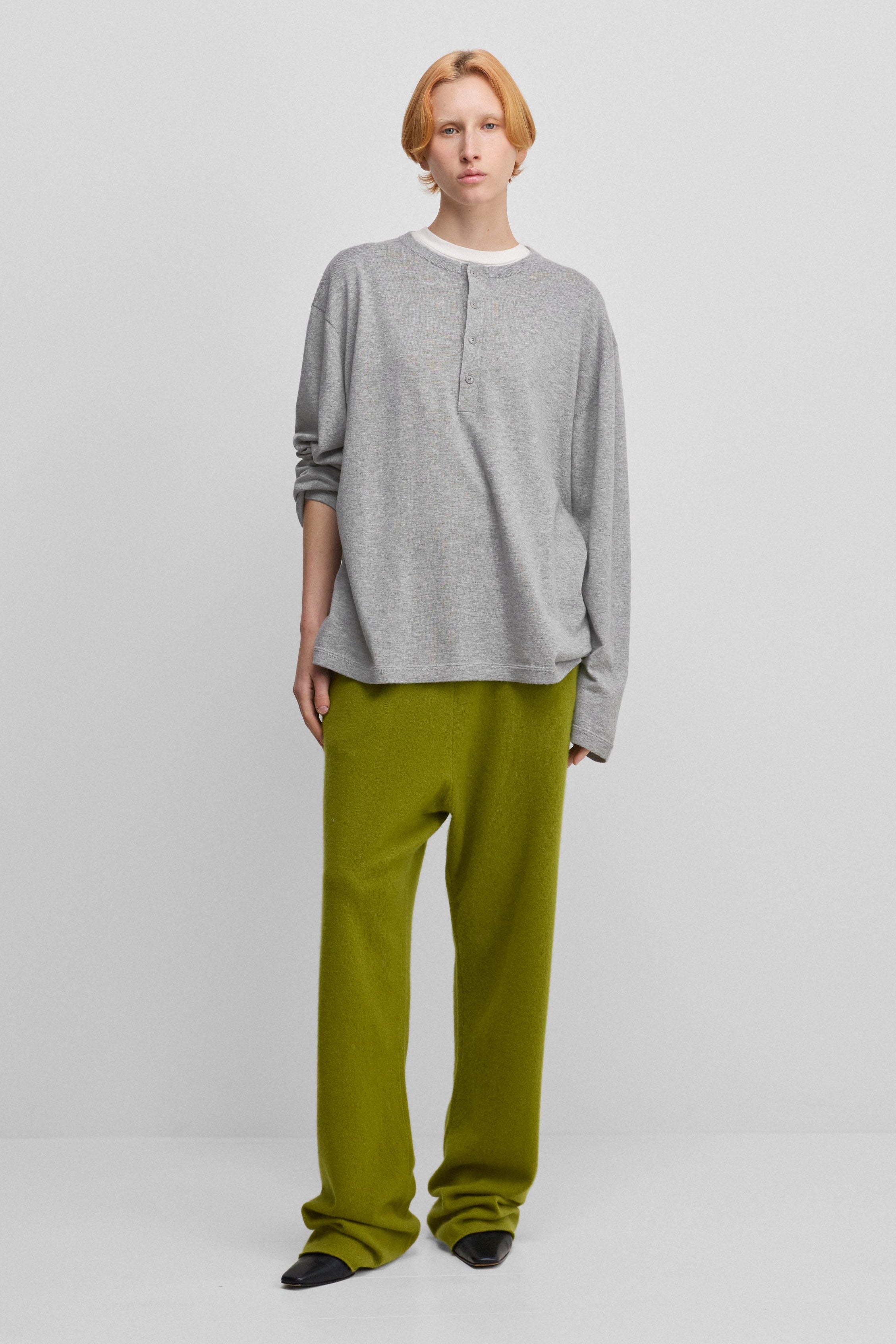 woman wearing green loose-fit cashmere pants with a drawstring waistband and side pockets.