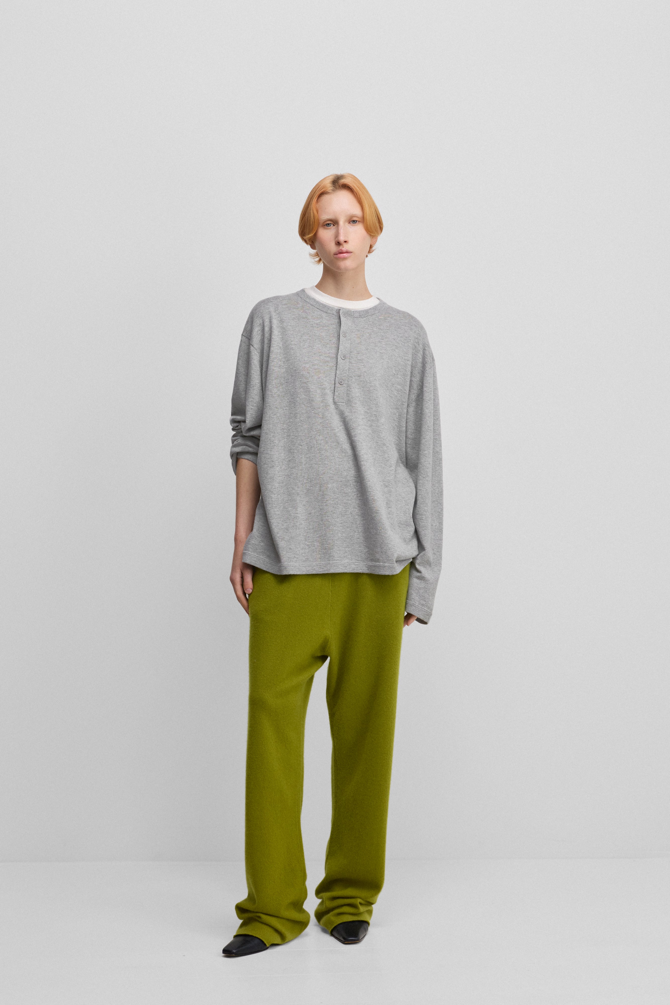 woman wearing green loose-fit cashmere pants with a drawstring waistband and side pockets.