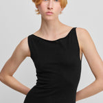 detail of the fitted top and boat neckline of black sleeveless wool cashmere dress.
