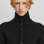 close-up of the rib-knitted collar of a black cashmere button-up cardigan.