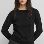 woman wearing a black cotton cashmere long-sleeved crew-neck top.