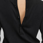 detail of the four corozo buttons on the back of a black cotton-cashmere long-sleeved top. 