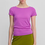 woman wearing a bright pink fitted wool cashmere t-shirt with a boat neck and short sleeves.