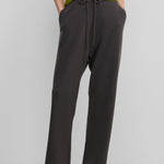 woman wearing dark grey loose-fit cashmere pants with a drawstring waistband and side pockets.