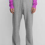 model wearing grey loose-fit cashmere pants with a drawstring waistband.