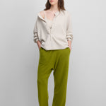 woman wearing green loose-fit cashmere pants with two side pockets.