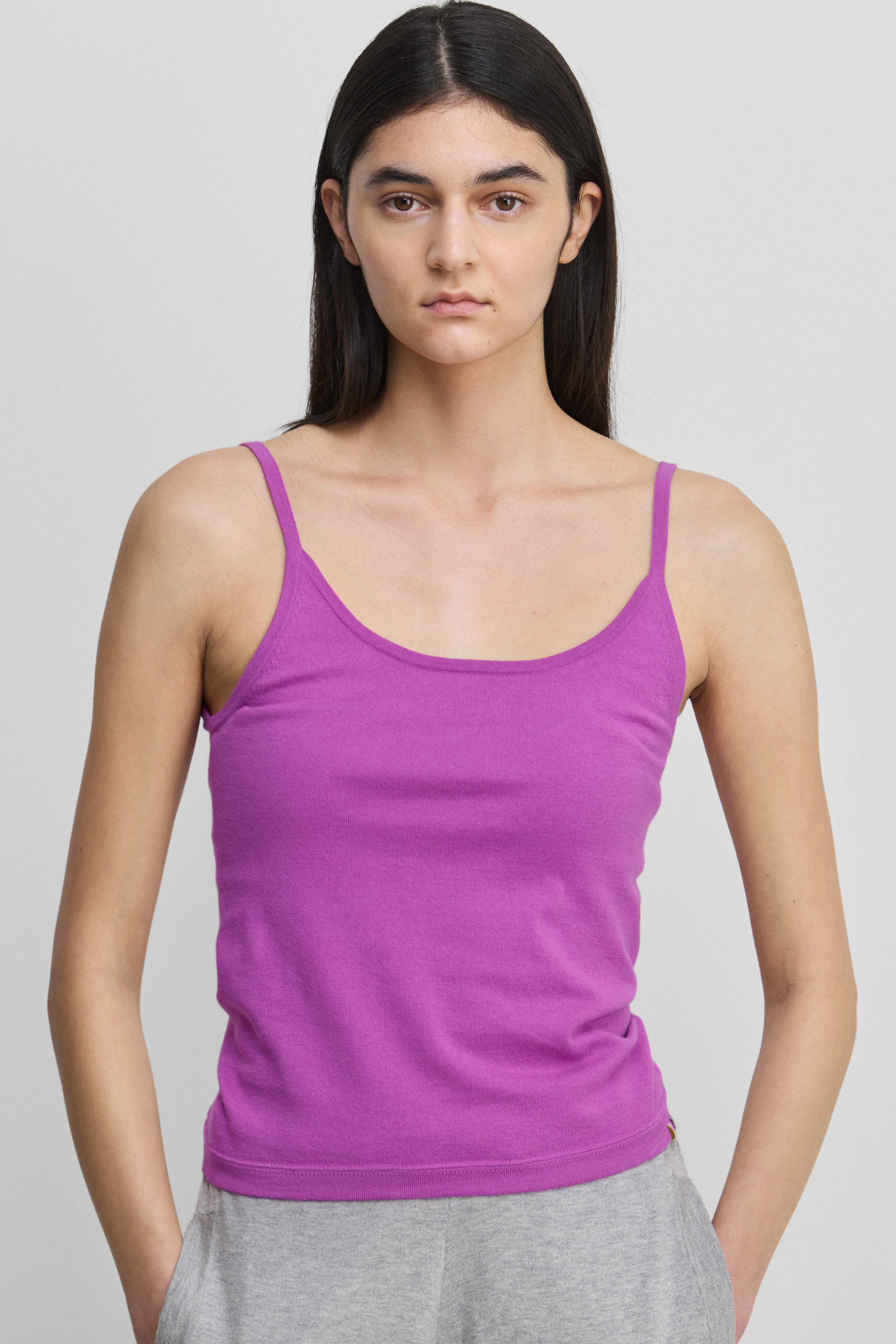 woman wearing a bright pink cotton cashmere strap top with a round neckline. 