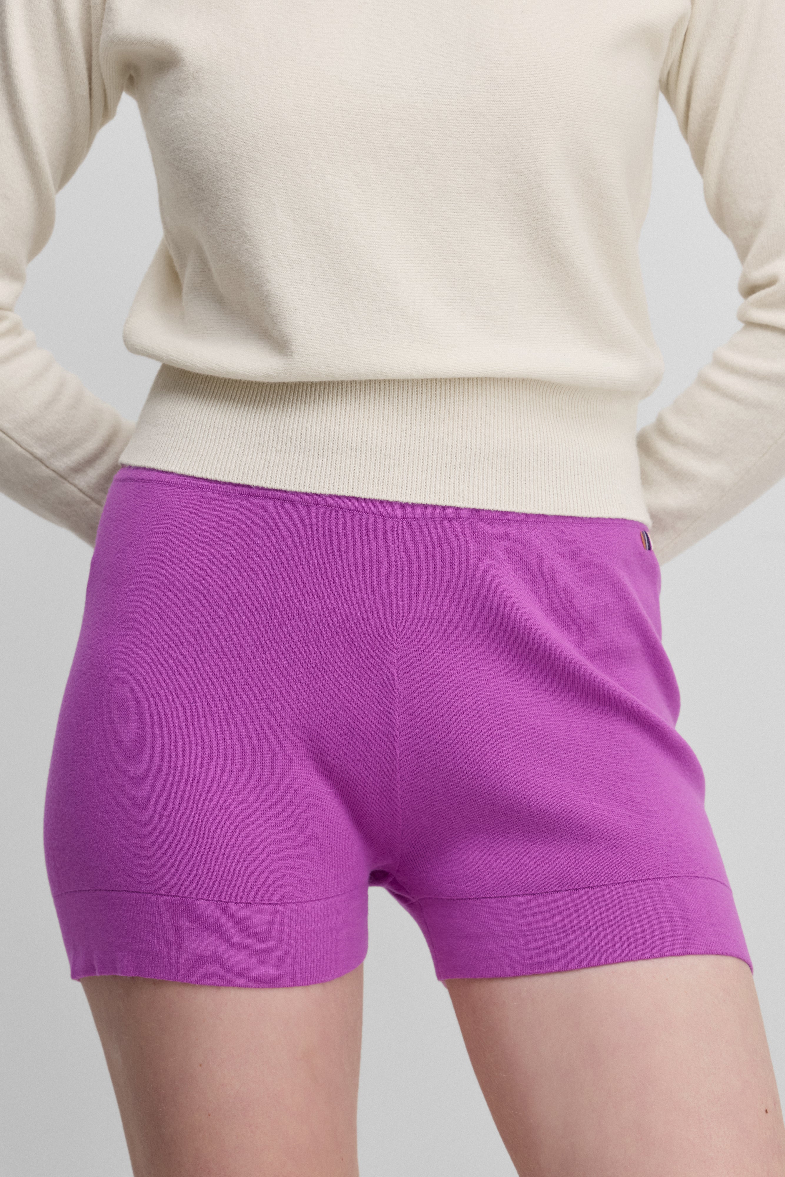 woman wearing fitted bright pink cotton cashmere rib-knit shorts.
