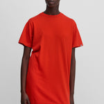 woman wearing a bright red cotton-cashmere mini t-shirt dress, styled with pink biker shorts.