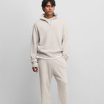 man wearing off-white loose-fit cashmere pants with two side pockets.