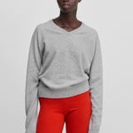 woman wearing a light grey classic-fit cashmere v-neck sweater.