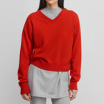 woman wearing a bright red classic-fit cashmere v-neck sweater with ribbed trims.