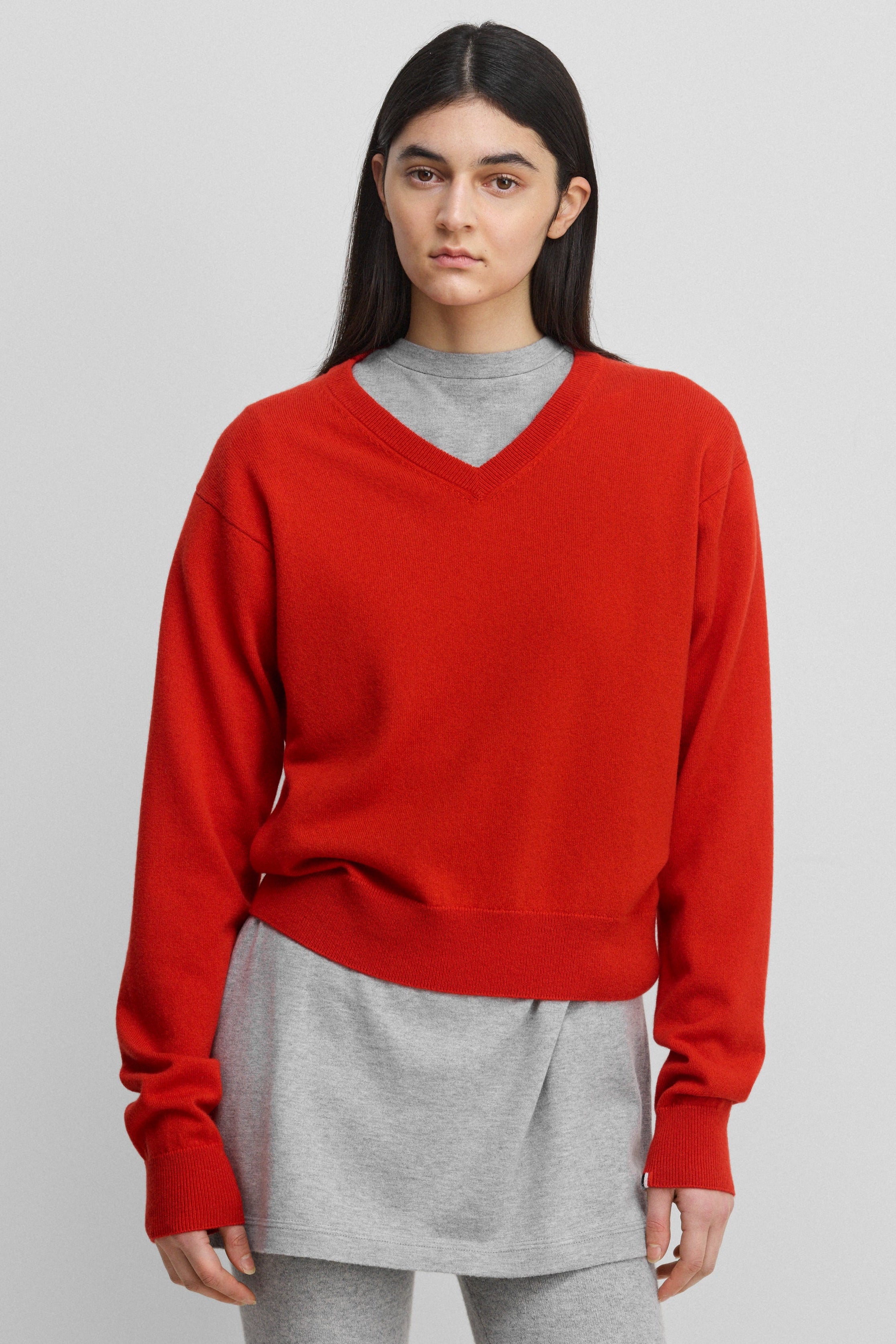 woman wearing a bright red classic-fit cashmere v-neck sweater with ribbed trims.
