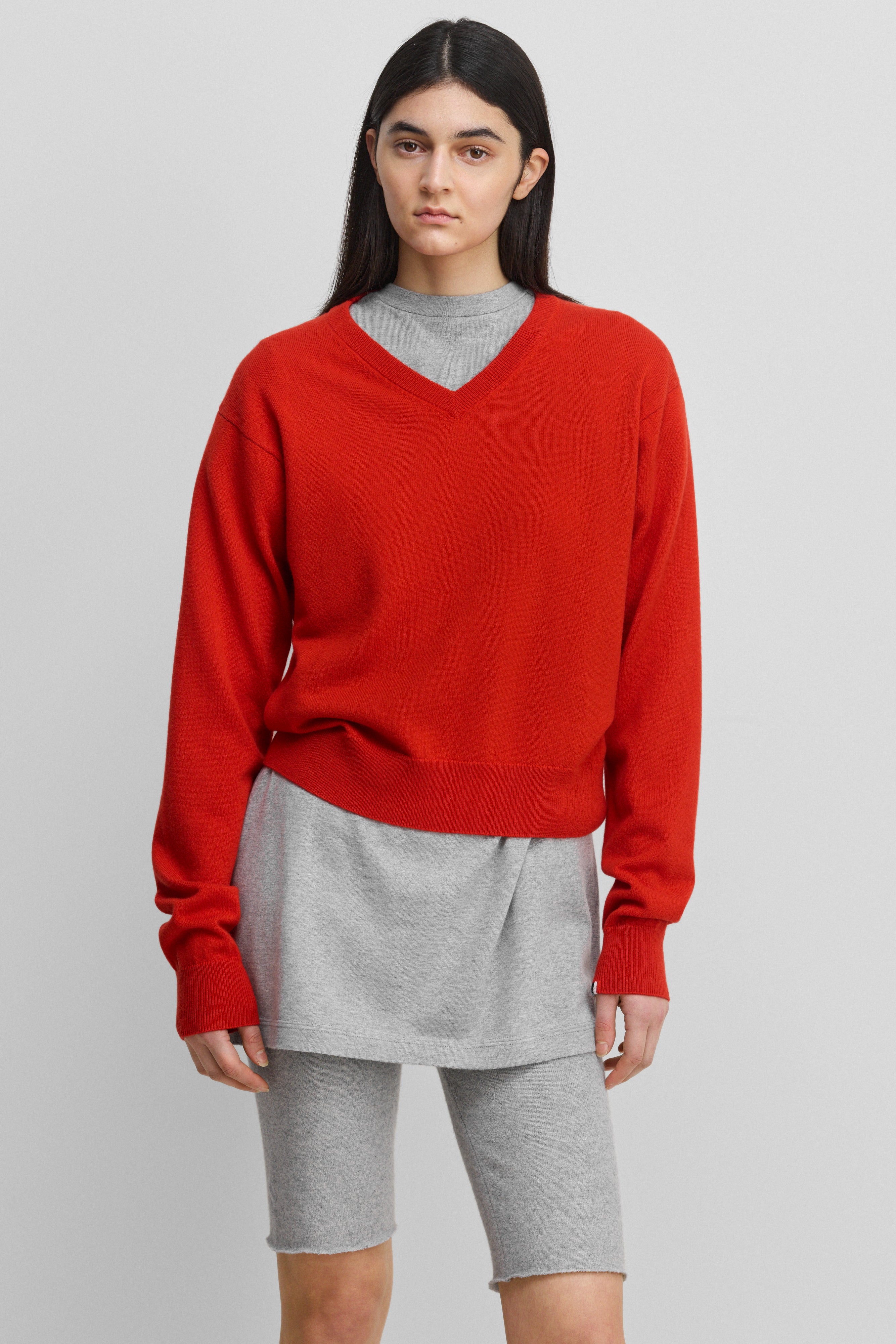 woman wearing a bright red classic-fit cashmere v-neck sweater with ribbed trims.