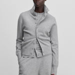 woman wearing a light grey cashmere button-up cardigan with a rib-knitted collar.
