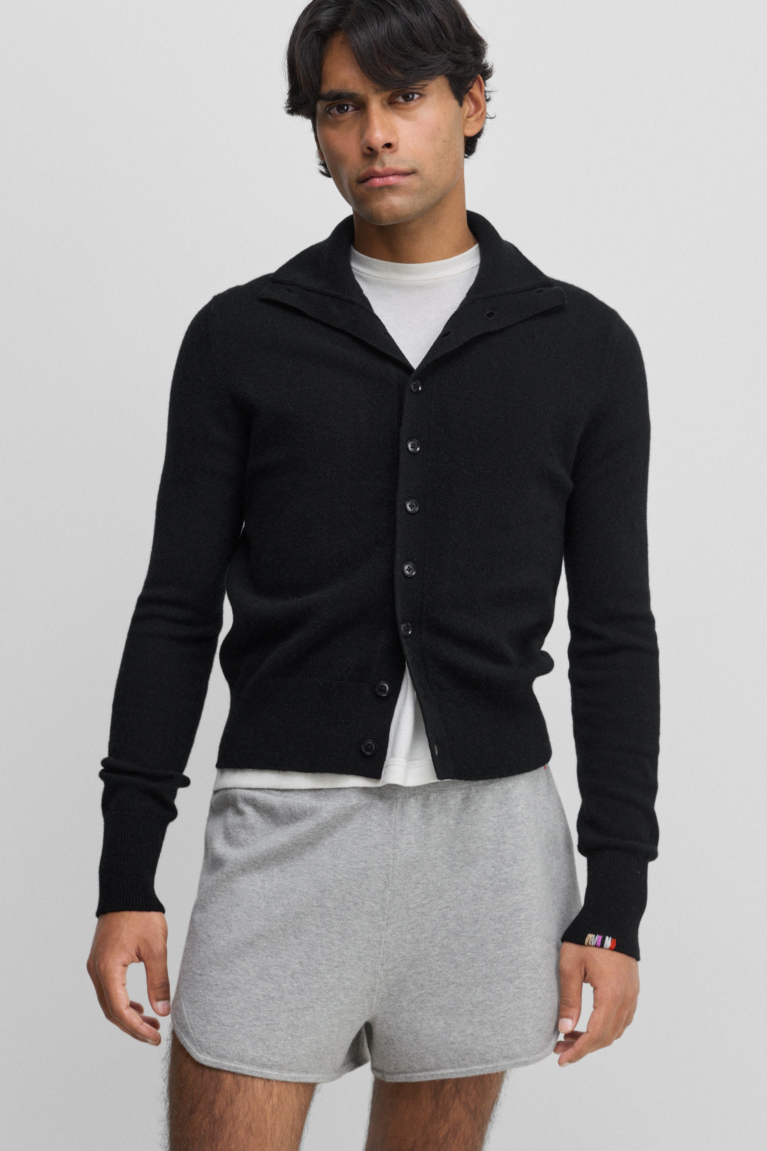 man wearing a black cashmere button-up cardigan with a rib-knitted collar.