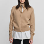 woman wearing a camel beige cashmere button-up cardigan with a rib-knitted collar.