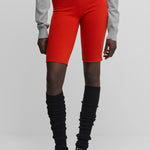 woman wearing bright red cashmere biker shorts with ribbed elasticated waistband.