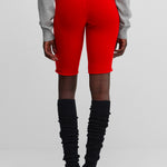 woman wearing bright red cashmere biker shorts with ribbed elasticated waistband, shown from the back.