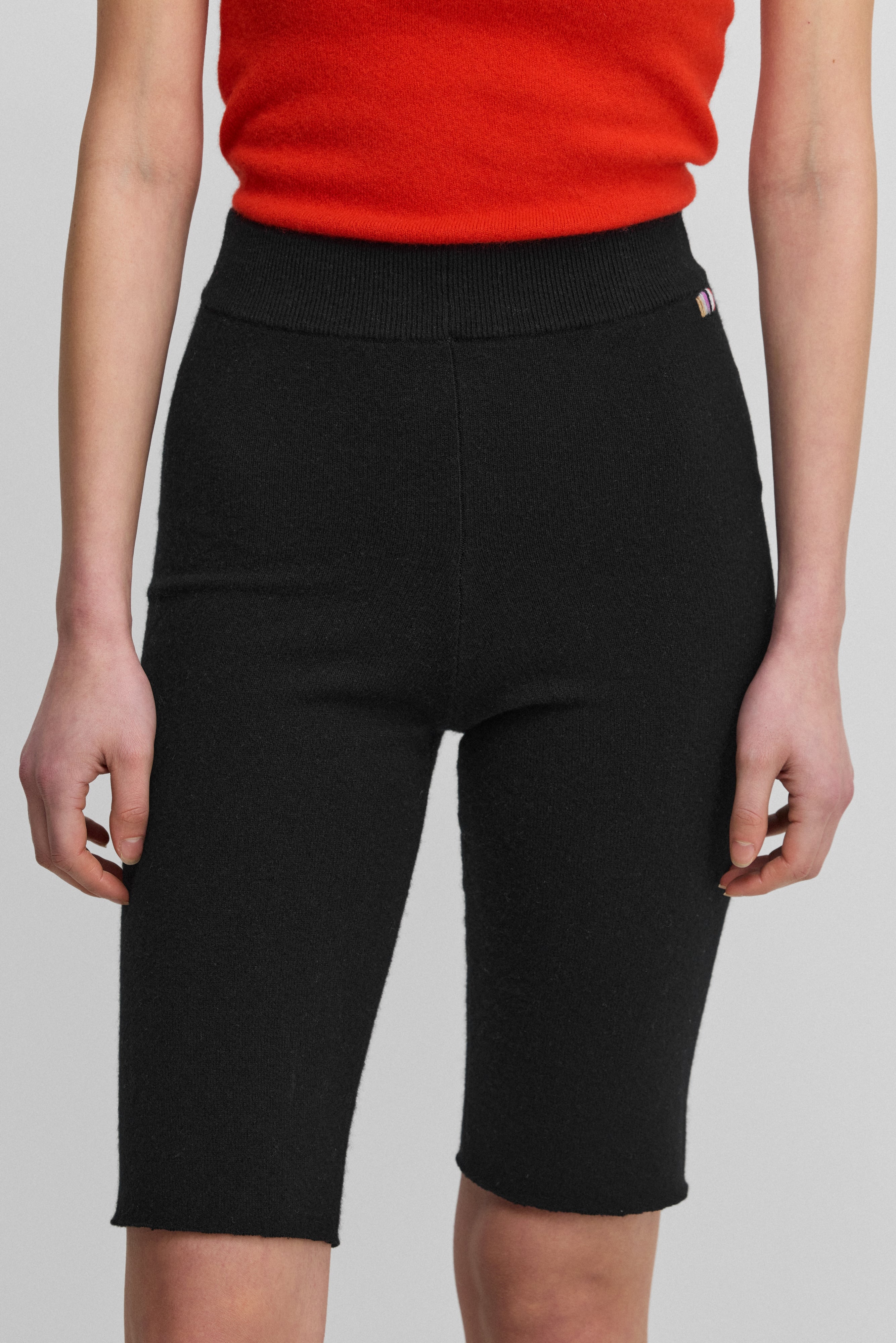 woman wearing black cashmere biker shorts with ribbed elasticated waistband.