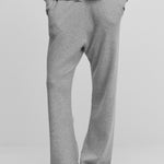 model wearing grey loose-fit cashmere pants with a drawstring waistband and side pockets.