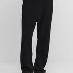 model wearing black loose-fit cashmere pants with two side pockets and a drawstring.