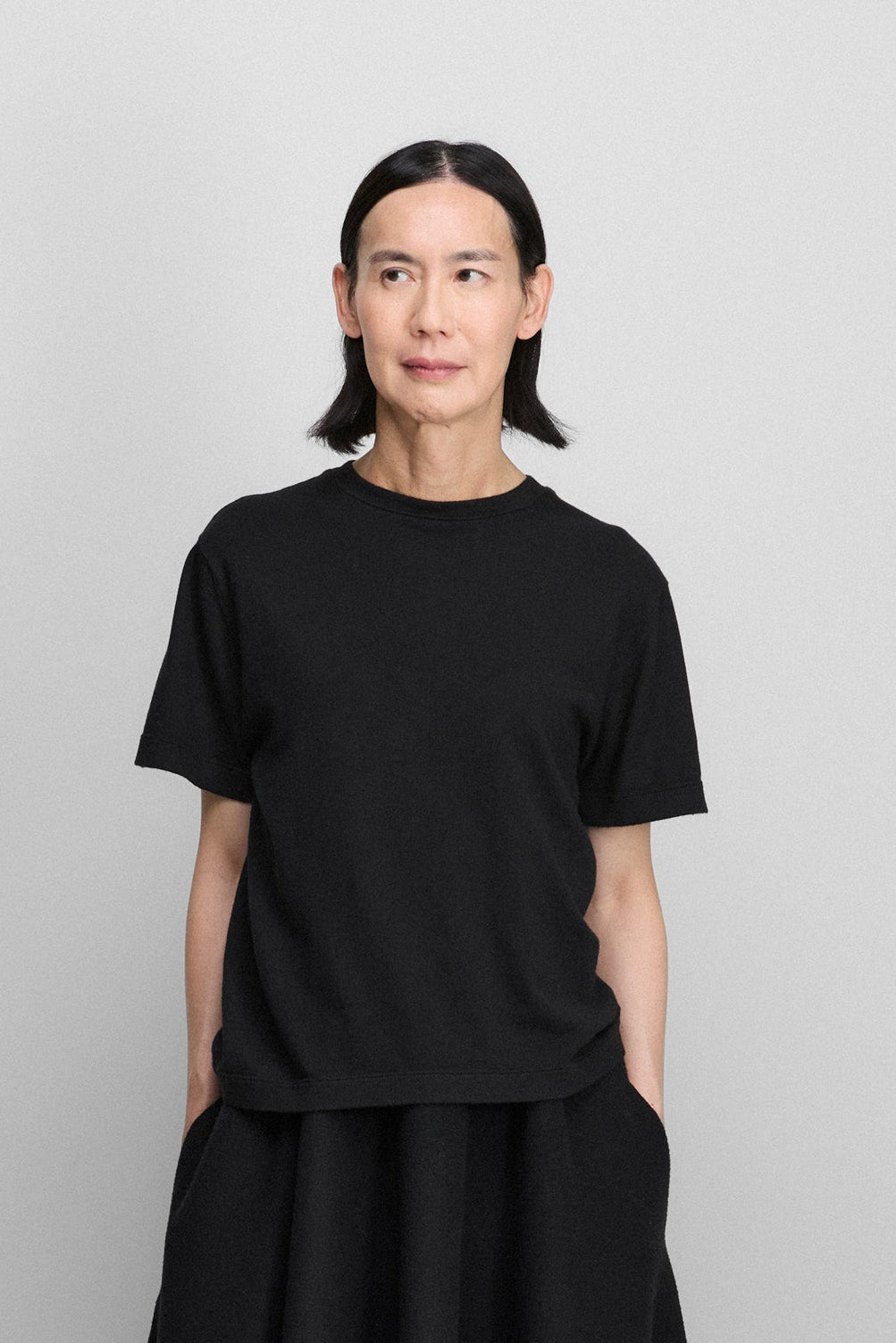 woman wearing a black short-sleeved cotton cashmere crewneck t-shirt.