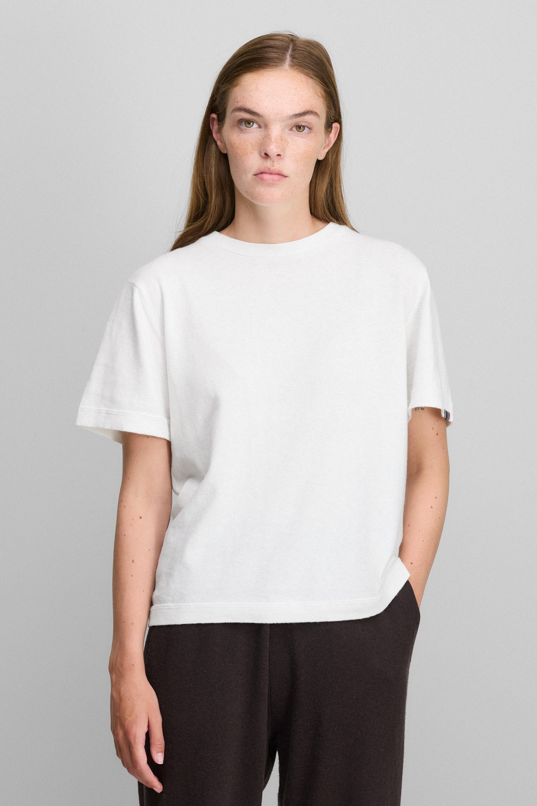 woman wearing a white short-sleeved cotton cashmere crewneck t-shirt.