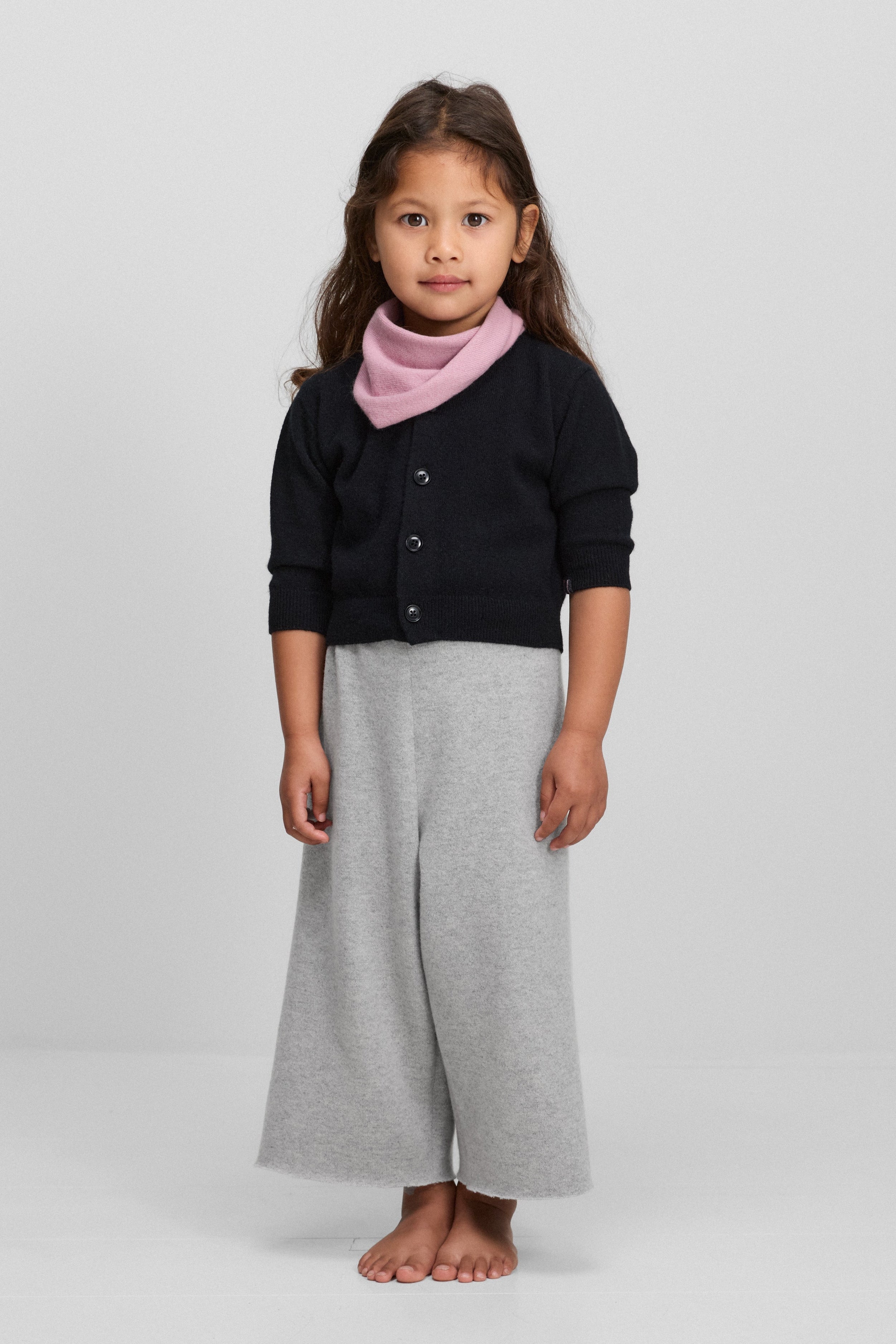 toddler wearing a children’s navy blue cashmere button up cardigan with a crew-neck, styled with grey pants.