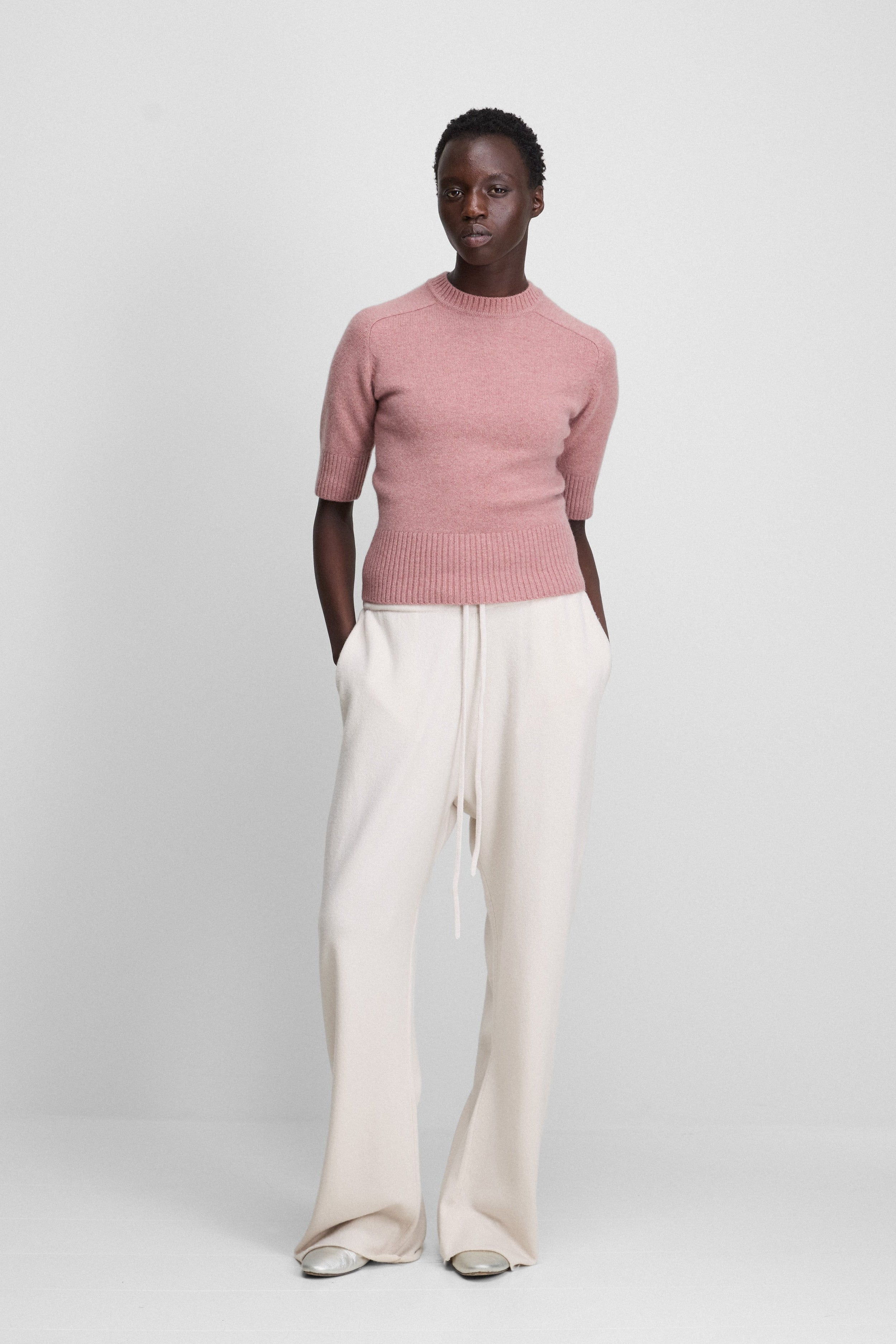 woman wearing oversized cashmere pants in white with drawstring and side pockets.
