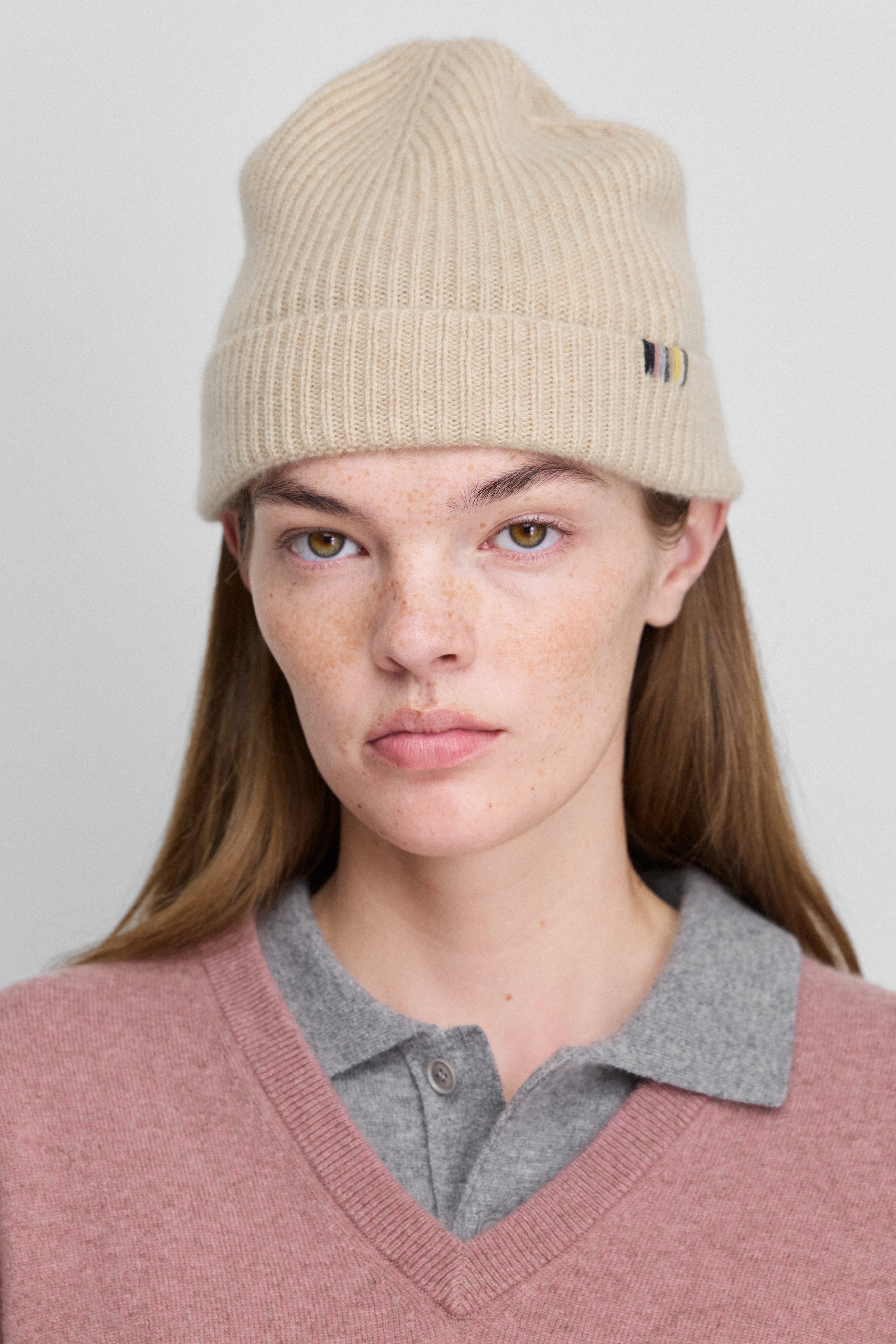 woman wearing a beige cashmere beanie in rib knit.