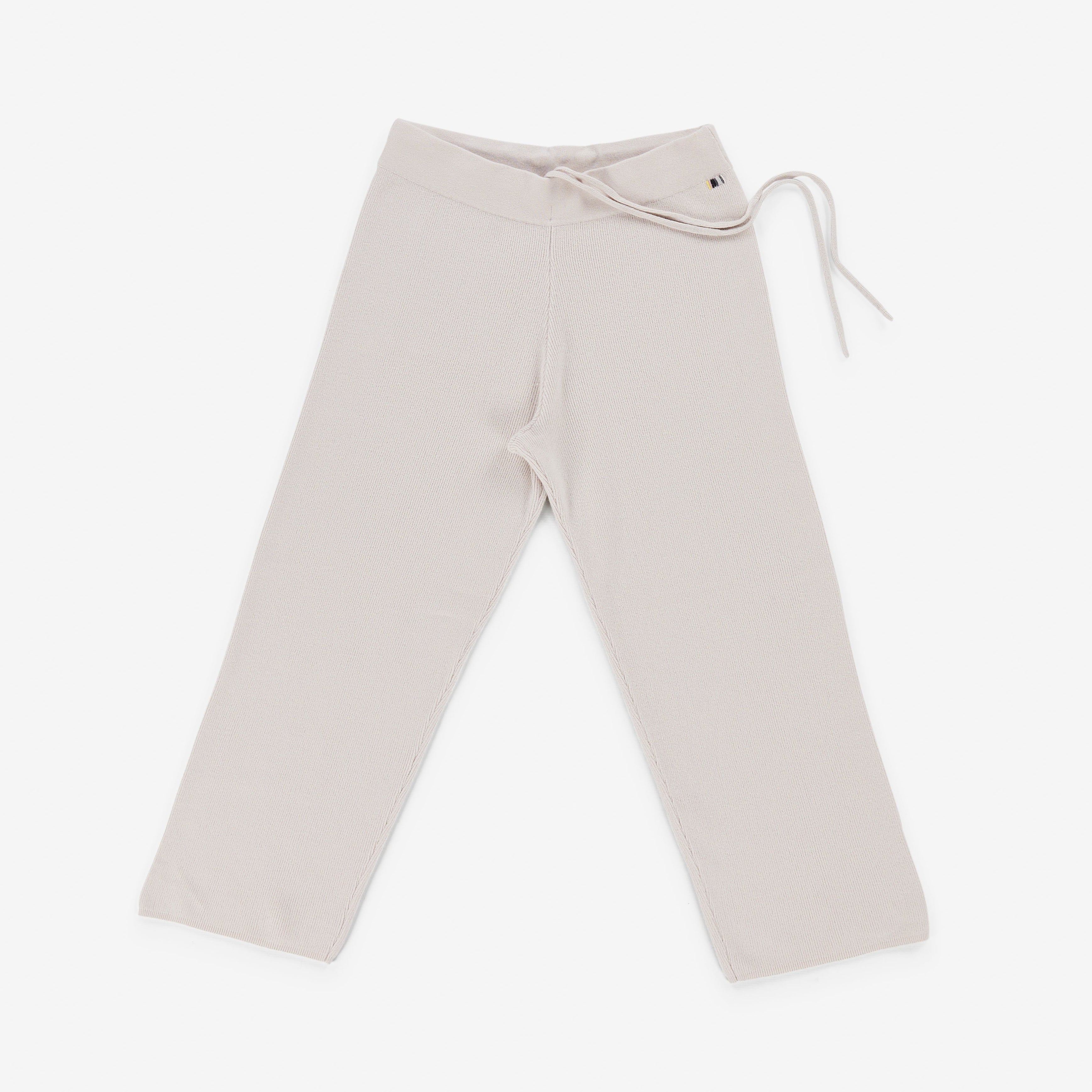 white rib-knit cashmere pants with straight legs and a drawstring waist, laid flat.
